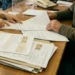 Contribuenti allo sportello con documenti e bollette durante una pratica amministrativa legata alla TARI