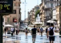 Persone in una città italiana durante una giornata di forte caldo estivo causato dall’ondata di calore