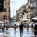 Persone in una città italiana durante una giornata di forte caldo estivo causato dall’ondata di calore