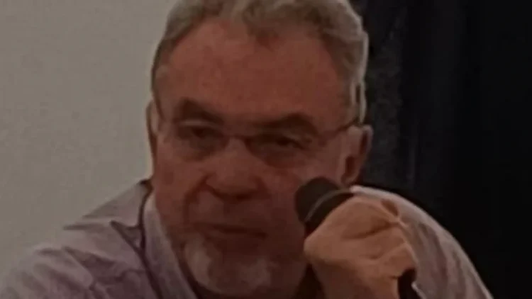Claudio Paterna durante un incontro pubblico con microfono in mano a Palermo.