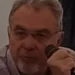 Claudio Paterna durante un incontro pubblico con microfono in mano a Palermo.