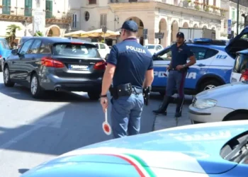 Agenti della Polizia di Stato impegnati nei controlli stradali nel centro di Modica durante le verifiche su auto e motocicli.