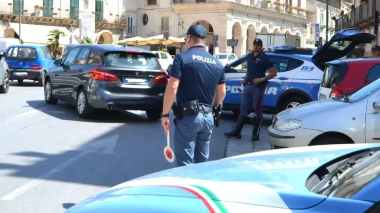 Agenti della Polizia di Stato impegnati nei controlli stradali nel centro di Modica durante le verifiche su auto e motocicli.