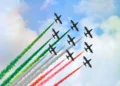 Formazione delle Frecce Tricolori durante un'esibizione con scie verde, bianca e rossa nel cielo