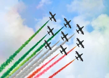 Formazione delle Frecce Tricolori durante un'esibizione con scie verde, bianca e rossa nel cielo
