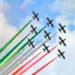 Formazione delle Frecce Tricolori durante un'esibizione con scie verde, bianca e rossa nel cielo