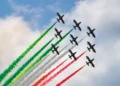 Le Frecce Tricolori sorvolano il cielo durante un'esibizione con i fumi verde, bianco e rosso