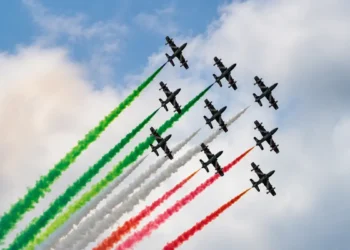 Le Frecce Tricolori sorvolano il cielo durante un'esibizione con i fumi verde, bianco e rosso