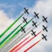 Le Frecce Tricolori sorvolano il cielo durante un'esibizione con i fumi verde, bianco e rosso