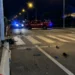 Forze dell'ordine e Vigili del Fuoco bloccano una strada di notte con strisce pedonali e detriti sull'asfalto.