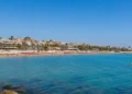 Panoramica della costa di Marina di Ragusa con mare calmo e cielo sereno durante un weekend estivo.