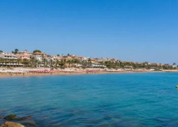Panoramica della costa di Marina di Ragusa con mare calmo e cielo sereno durante un weekend estivo.