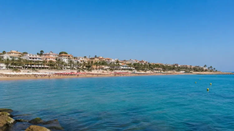 Panoramica della costa di Marina di Ragusa con mare calmo e cielo sereno durante un weekend estivo.