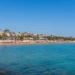 Panoramica della costa di Marina di Ragusa con mare calmo e cielo sereno durante un weekend estivo.