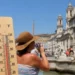 Turisti e fontana in una giornata di forte caldo con termometro in primo piano e temperature elevate
