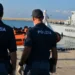 Agenti della Polizia di Stato e della Guardia di Finanza durante le operazioni di sbarco dei migranti nel porto di Pozzallo