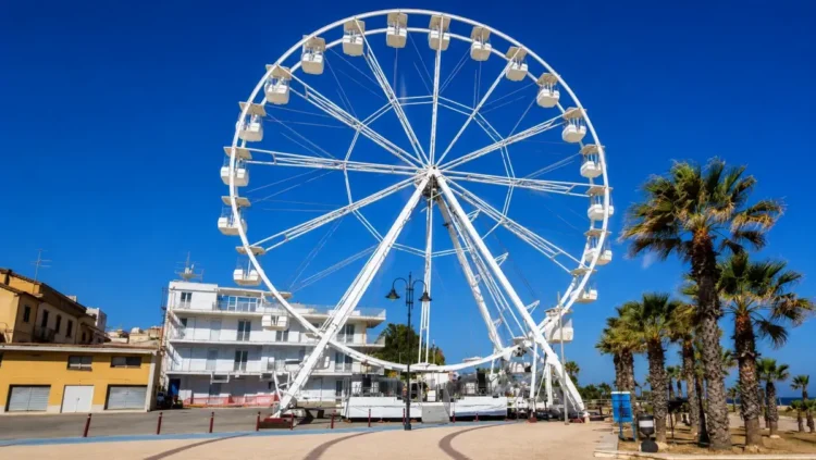 Ruota panoramica installata sul lungomare di Raganzino a Pozzallo con cabine panoramiche e vista sulla zona costiera.