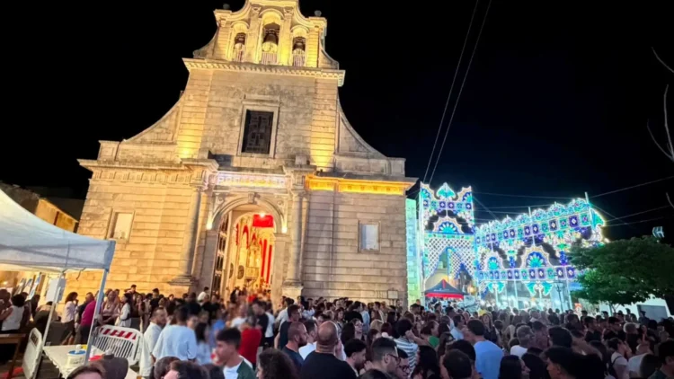 Fedeli e visitatori davanti alla chiesa di San Giovanni Battista durante i festeggiamenti serali a Chiaramonte Gulfi.