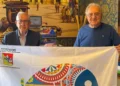 Due rappresentanti locali mostrano la bandiera REIMAR durante un'iniziativa dedicata alle identità marinare siciliane.