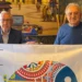 Due rappresentanti locali mostrano la bandiera REIMAR durante un'iniziativa dedicata alle identità marinare siciliane.