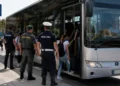Autobus extraurbano con personale delle forze dell'ordine e passeggeri presso una fermata in Sicilia