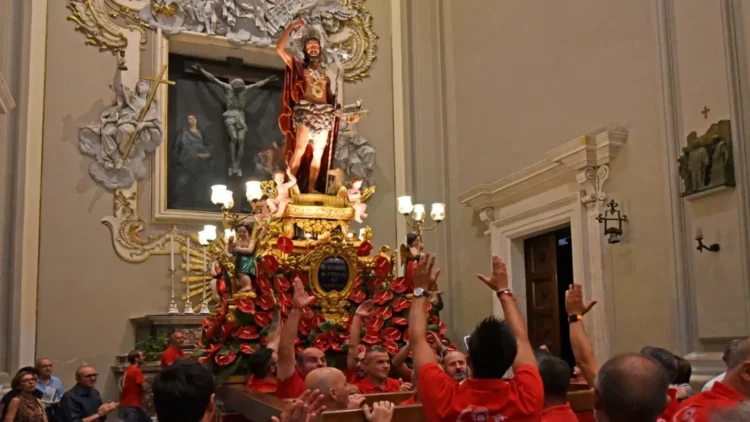 Fedeli e portatori durante una celebrazione dedicata a San Giovanni Battista nella cattedrale di Ragusa