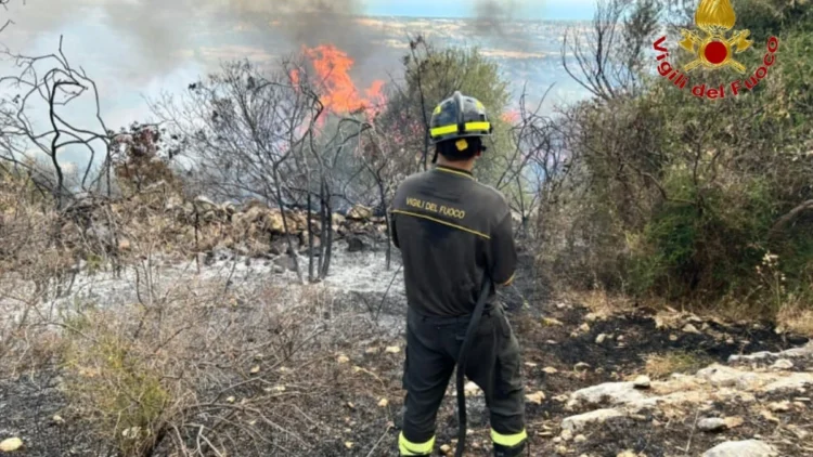Vigile del fuoco impegnato nelle operazioni di spegnimento del vasto incendio sviluppatosi in contrada Pozzillo a Ragusa