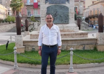 Andrea La Rosa posa davanti al monumento commemorativo in una piazza del centro storico di Vittoria