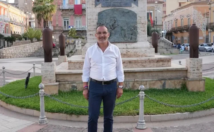 Andrea La Rosa posa davanti al monumento commemorativo in una piazza del centro storico di Vittoria