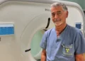 Il dottor Claudio Caputo posa davanti a una TAC nel reparto di Radiologia dell'ospedale "Giovanni Paolo II" di Ragusa dopo la nomina a direttore dell'Unità Operativa Complessa.