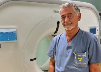 Il dottor Claudio Caputo posa davanti a una TAC nel reparto di Radiologia dell'ospedale "Giovanni Paolo II" di Ragusa dopo la nomina a direttore dell'Unità Operativa Complessa.