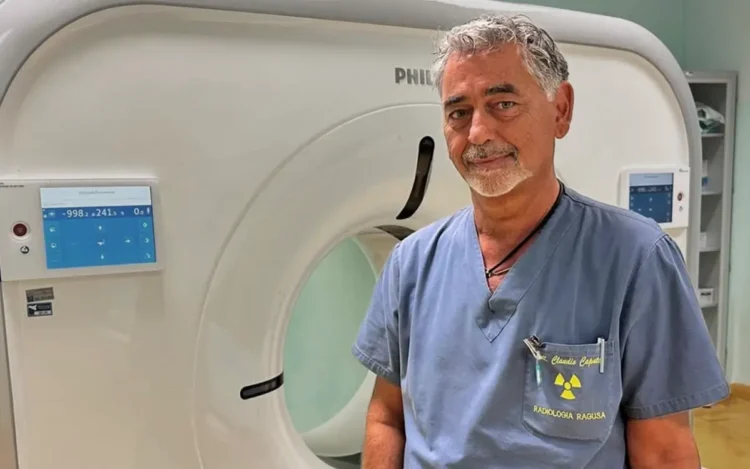 Il dottor Claudio Caputo posa davanti a una TAC nel reparto di Radiologia dell'ospedale "Giovanni Paolo II" di Ragusa dopo la nomina a direttore dell'Unità Operativa Complessa.