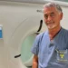 Il dottor Claudio Caputo posa davanti a una TAC nel reparto di Radiologia dell'ospedale "Giovanni Paolo II" di Ragusa dopo la nomina a direttore dell'Unità Operativa Complessa.