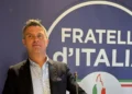 Luca Poidomani, coordinatore cittadino di Fratelli d'Italia a Ragusa, durante un intervento davanti al logo del partito.