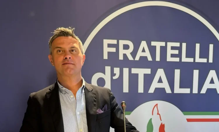 Luca Poidomani, coordinatore cittadino di Fratelli d'Italia a Ragusa, durante un intervento davanti al logo del partito.
