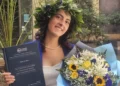 Giulia Di Salvo posa con la tesi di laurea e un mazzo di fiori dopo aver conseguito la laurea in Scienze Politiche con 110 e lode all'Università di Catania