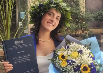 Giulia Di Salvo posa con la tesi di laurea e un mazzo di fiori dopo aver conseguito la laurea in Scienze Politiche con 110 e lode all'Università di Catania