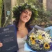 Giulia Di Salvo posa con la tesi di laurea e un mazzo di fiori dopo aver conseguito la laurea in Scienze Politiche con 110 e lode all'Università di Catania