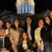 Componenti del gruppo consiliare IdeAzione posano in una foto di gruppo in piazza a Comiso, con la cupola della chiesa illuminata sullo sfondo durante una serata.