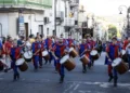 I Tamburi di Giarratana in costume medievale sfilano durante il MeMuFest lungo una strada del centro storico, accompagnati dal pubblico