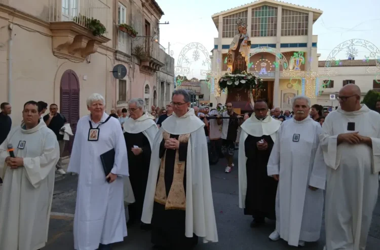 La processione della Madonna del Carmine attraversa il centro storico di Ragusa con il simulacro della Vergine, accompagnato dai Padri Carmelitani Scalzi e da numerosi fedeli davanti al santuario