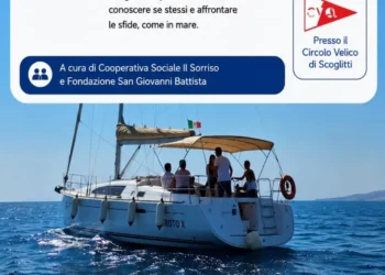 Una barca a vela con bambini, ragazzi e operatori durante un laboratorio di vela educativa nelle acque di Scoglitti, nell'ambito del progetto "Sprigiona il tuo cuore".