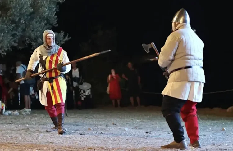 Due rievocatori in abiti medievali si affrontano durante un combattimento storico al MeMuFest 2026 di Giarratana, davanti al pubblico