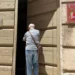 Ingresso del Museo Civico "L'Italia in Africa" di Ragusa con il portone socchiuso e una persona davanti all'entrata.