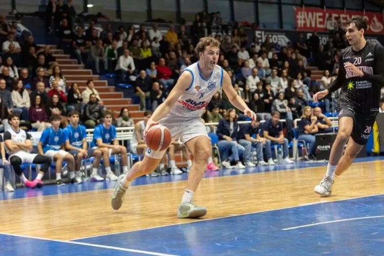 Mait Peterson della SuperConveniente Virtus Ragusa conduce il pallone in attacco durante una partita di campionato, con un avversario in marcatura e il pubblico sugli spalti del PalaPadua