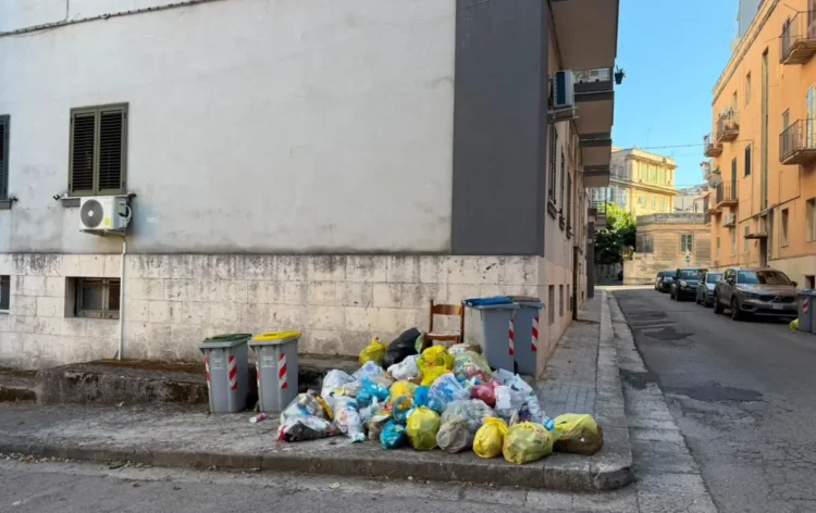 Cumulo di sacchetti dei rifiuti abbandonati accanto ai cassonetti in piazza Monsignor Arezzi, nel centro storico di Ragusa.