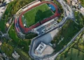 Vista aerea dello stadio Pietro Scollo di Modica con il campo da calcio, la pista di atletica e il settore della curva destinato ai tifosi ospiti.