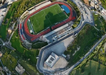 Vista aerea dello stadio Pietro Scollo di Modica con il campo da calcio, la pista di atletica e il settore della curva destinato ai tifosi ospiti.
