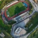 Vista aerea dello stadio Pietro Scollo di Modica con il campo da calcio, la pista di atletica e il settore della curva destinato ai tifosi ospiti.