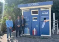Tre rappresentanti posano accanto a un ecocompattatore RecoPet di COREPLA destinato alla raccolta delle bottiglie in PET, installato nell'ambito del nuovo progetto avviato dal Comune di Ragusa